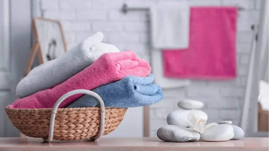 Toallas de colores apiladas sobre una superficie, listas para el lavado